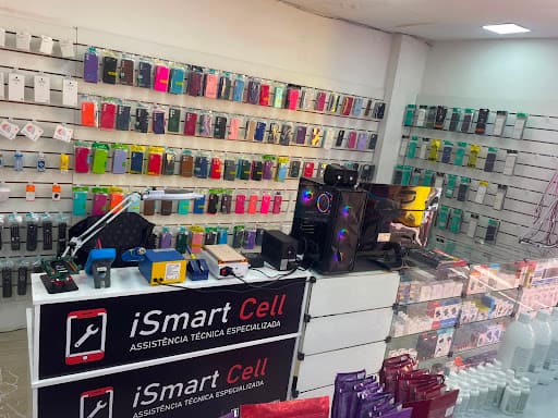 Interior da loja iSmart Cell com balcão de atendimento, bancada de reparo e parede repleta de capinhas coloridas